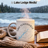White mug with "Lake Guntersville Alabama" compass design, steam rising, by a window.