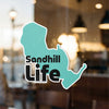 Teal Sandhill Life sticker with black text on glass.
