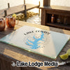 A glass cutting board featuring a blue map of Lake Conroe, Texas, sits on a wooden outdoor bar.