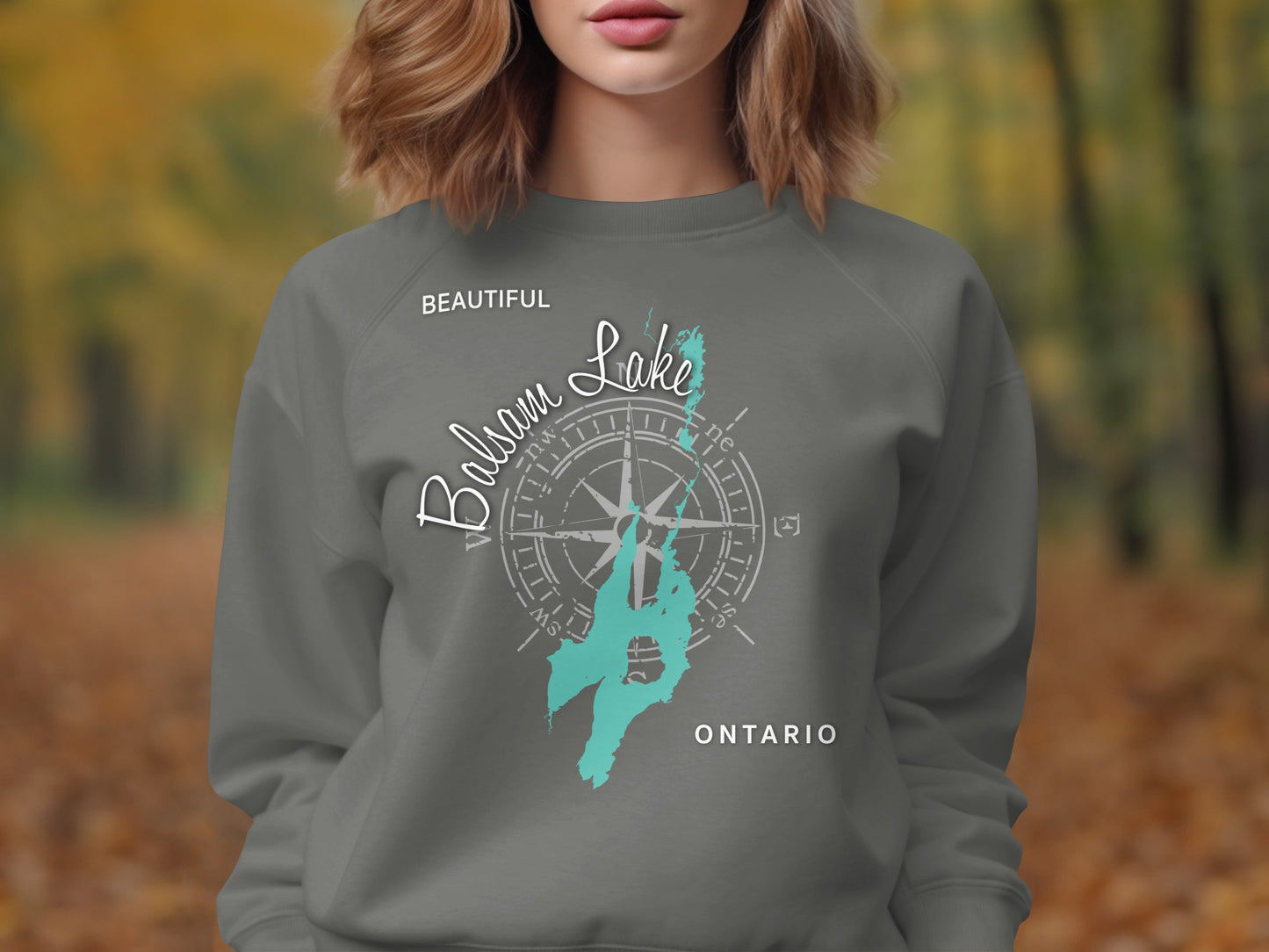 Gray sweatshirt with "Balsam Lake Ontario" compass graphic and teal lake outline.