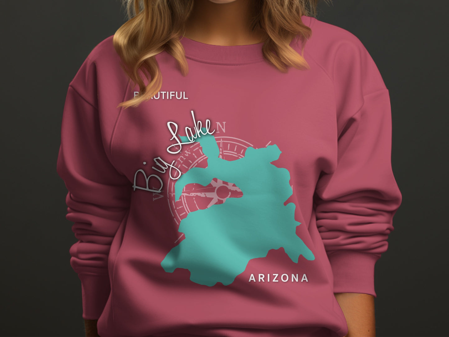 Teal Big Lake map graphic with compass on pink sweatshirt.