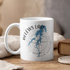 White mug with BeLews Lake and North Carolina map design and compass rose.
