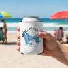 White koozie with Marco Island Florida map design, held on a beach.