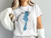 White t-shirt with blue map of Barlow Lake, Michigan, and compass design.