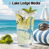Glass with drink, limes, mint, and "Lake Lure" design on a beach background.