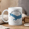 White mug with blue Harlan County Lake silhouette and compass graphic, and "Nebraska" text.