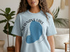 Light blue t-shirt with Newnans Lake graphic and location text in white and black. Swamp Blue Florida.