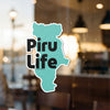 Teal sticker with "Piru Life" text, adhered to a glass surface.