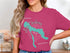 Pink t-shirt featuring a teal outline map of Lake Charlevoix and compass rose.
