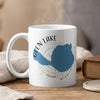 White mug with Glen Lake Michigan map design and steam rising.