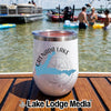 A white stemless wine tumbler with a Grenada Lake Mississippi design rests on a wooden boat deck.
