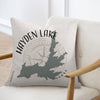 Pillow with Hayden Lake Idaho map and compass design on light fabric.