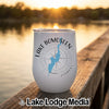 A white insulated wine tumbler featuring a blue outline of Lake Bomoseen, compass graphic, and text resting on a wooden dock at sunset.