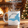 White mug with Lake Gregory California design and splashing coffee.