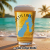 Glass of beer with "Fayette Lake" text and Idaho outline on beach background.