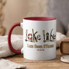 White mug with red handle featuring "Lake Life" artwork and "Lake Coeur D'Alene Idaho."