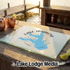 A rectangular glass cutting board featuring a blue map design of Lake Tawakoni rests on a wooden outdoor bar.