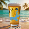 Glass of beer with Hayden Lake map and compass on beach with palm trees.