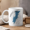 White mug with Trout Lake New York map and compass design, with steam rising.