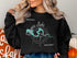 Black sweatshirt with "Beautiful Saguaro Lake Arizona" and compass rose graphic.