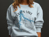 Light blue sweatshirt with Stockton Lake Missouri map and compass design.