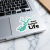 Turquoise lake outline sticker with "Your Custom Life" text on laptop.
