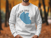 White sweatshirt with blue Hauser Lake Idaho graphic and compass rose.