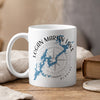 White mug with Logan Martin Lake map and compass design, steaming hot.