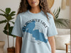 Light blue t-shirt with a blue shape of Clearwater Lake, Minnesota and compass design.