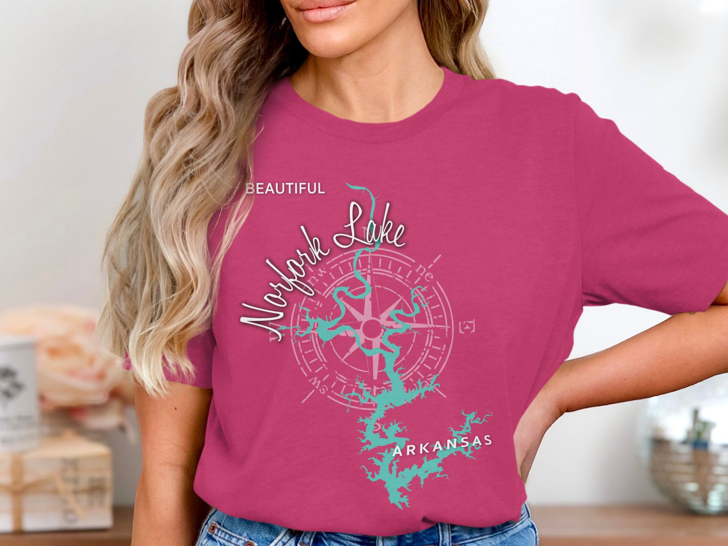 Pink t-shirt featuring a teal graphic of Norfork Lake, Arkansas with a compass rose.
