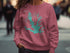 Maroon sweatshirt with Louisville Lake map and compass graphic.
