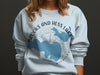 Light blue sweatshirt with "Brooks and Hess Lake Michigan" graphic and compass design.