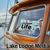 Watauga Life sticker on a wooden boat window, with Lake Lodge Media logo below.