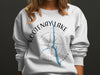 White sweatshirt with Kootenay Lake graphic and compass rose design.