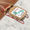 Wooden sleigh ornament with red runners and rope, reads "Merry Christmas FROM Forest Lake".