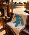 Woven blanket with Lake Huron map design on a leather couch.
