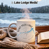 White mug with "Fort Peck Lake Montana" and compass design, steaming hot.