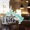 Turquoise Skiatook Life sticker superimposed over a blurry window background.
