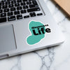 Turquoise sticker with "Newnans Life" text on a laptop keyboard.