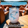 A white travel wine tumbler printed with a blue map of Lake Lahontan and a compass rose rests on a wooden boat table.
