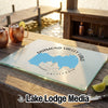 A glass cutting board featuring a map of Diamond Valley Lake rests on a wooden bar overlooking the water.