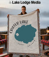 Crater Lake Oregon map on woven throw blanket held by smiling man.