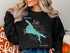 Black sweatshirt with teal Canyon Lake Arizona map and compass graphic.