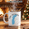White mug with Lake Michigan map design and compass, next to a fireplace and Christmas tree.