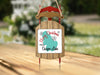 Sled ornament with "Merry Christmas From Ossipee Lake" text and snowflakes.