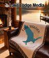 Woven blanket with Lake Siskiyou, California silhouette on a leather sofa.