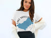 White t-shirt with a blue Lake Mascuppic graphic and compass design.