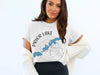 White t-shirt with "Prior Lake Minnesota" and a compass design featuring a lake map.