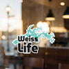 "Weiss Life" text sticker with turquoise lake outline on glass.