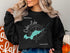 Black sweatshirt with "Beautiful Cedar Lake Ontario" and map graphic.